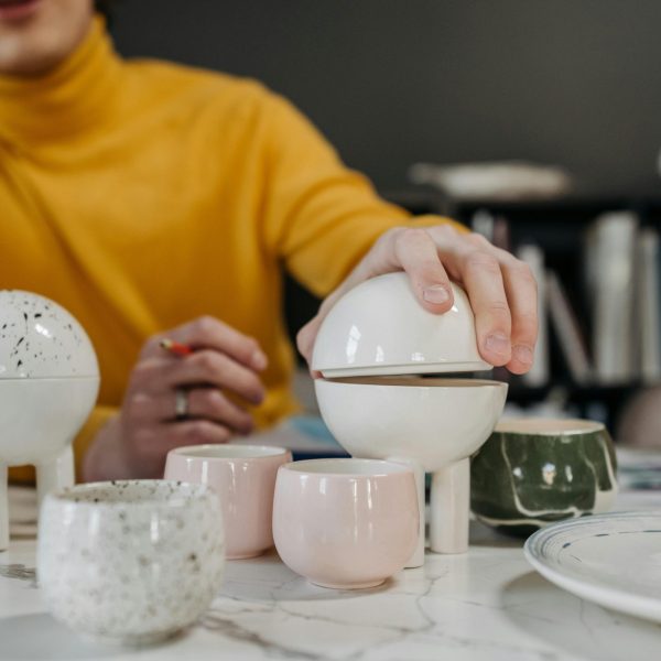 A creative pottery setup with modern designs featuring teacups and decorative items in a studio.